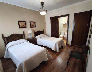a hotel room with two beds and a mirror at COMPLEJO TURISTICO LOS AZORES in Fuencaliente