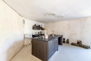 uma cozinha com uma ilha negra num quarto em Blockhaus 44 em Ver-sur-Mer