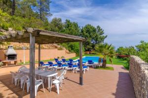 un patio con mesa y sillas y una piscina en Marimuntanya en Lloret de Mar