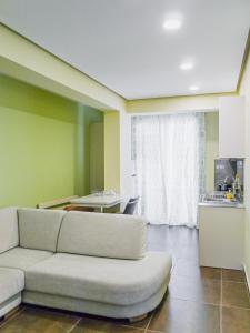 un soggiorno con divano bianco e una cucina di Apartment Te Kalua 2 a Sarandë