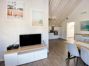 a living room with a television and a table and chairs at Wunderschöne helle Wohnung mit großer Dachterrasse in Gottmadingen