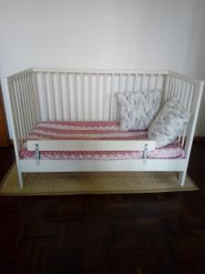 a white crib with two pillows on it at Quarto di Luna in Genoa