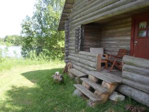 a wooden cabin with a chair sitting outside of it at Pähnamäe metsamajake in Ruusmäe +14 photos