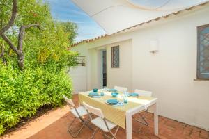 - une table et des chaises blanches sur la terrasse dans l'établissement Cozy apartment Lemon San Pantaleo, à Olbia