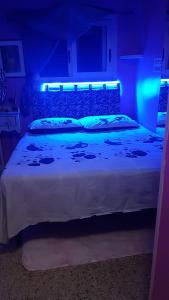 サン・フェリーチェ・チルチェーオにあるAppartamento Panoramicoのベッドルーム(青色の照明付きの白い大型ベッド1台付)