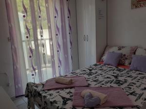 a bedroom with a bed with towels and a window at Apartmani Stanković in Podaca