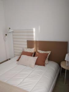 una gran cama blanca con almohadas encima en Angel's House, en Quinta do Anjo