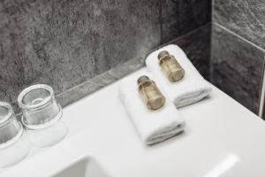 ein Badezimmer mit zwei Flaschen und Handtüchern auf einem Waschbecken in der Unterkunft Hotel Spescha in Lenzerheide