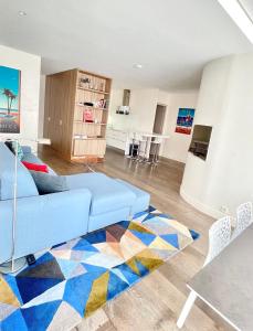 a living room with a blue couch and a colorful rug at Luxurious 2 Bedrooms Apartment, 30 meter from beach in Nice
