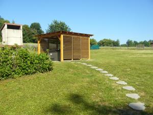 a small wooden shed in a field with a grass yard at Appartement dans maison à Corbelin proche Walibi in Corbelin