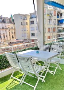 d'une table blanche et de deux chaises sur un balcon. dans l'établissement Luxurious 2 Bedrooms Apartment, 30 meter from beach, à Nice
