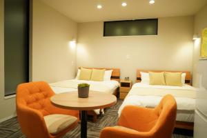 a hotel room with two beds and a table and chairs at Koti Sopo Universal Bay 3 by Liaison in Osaka