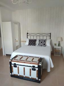 Apartamento La Placeta في مونرويو: غرفة نوم بسرير لحاف اسود وبيض