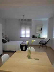 Apartamento La Placeta في مونرويو: غرفة مع طاولة مع إناء من الزهور عليها