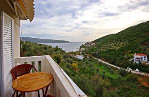 Un balcón con una mesa de madera y sillas y el océano. en Enjoy the silence-Αlonnisos, en Kalamakia