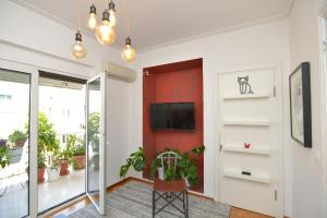 uma sala de estar com uma parede de acento vermelho e uma porta de correr em Athens Stylish top floor apartment Syntagma metro em Atenas