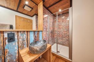 a bathroom with a stone sink and a brick wall at Landhotelwohnung in Seeg in Seeg