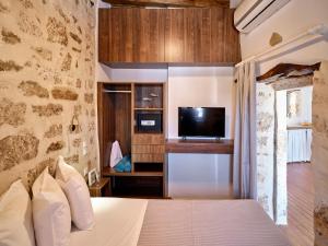 a bedroom with a bed and a tv in a room at Kambos House in Kimolos