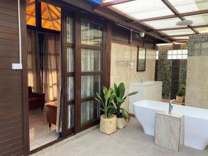 uma casa de banho com uma banheira e um lavatório em Compass Atauro Eco Lodge em Beloi