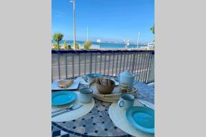 a table with blue plates and utensils on a balcony at La cabine de Léontine in La Baule