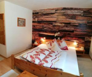 a bedroom with a bed with a stone wall at Temelerhof in Gries im Sellrain