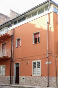 een oranje gebouw met ramen en een balkon bij Appartamento In Paese in Niscemi
