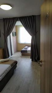Schlafzimmer mit einem Bett, einem Fenster und einer Tür in der Unterkunft Family Hotel Malibu in Tschernomorez