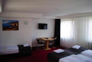 ein Hotelzimmer mit 2 Betten und einem Schreibtisch in der Unterkunft Hotel Continental Koblenz in Koblenz