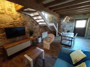un soggiorno con divano blu e TV di O RINCÓN DE NOAH a Finisterre