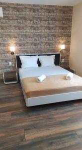 ein Schlafzimmer mit einem großen Bett mit Ziegelwand in der Unterkunft Family Hotel Malibu in Tschernomorez