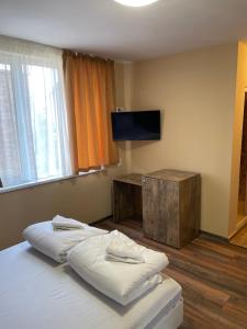 Schlafzimmer mit einem Bett und einem Flachbild-TV in der Unterkunft Family Hotel Malibu in Tschernomorez