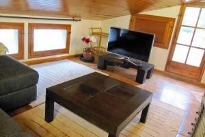 sala de estar con TV de pantalla plana y mesa de centro en Guesthouse "La Gloria de Arbolí" en Arboli