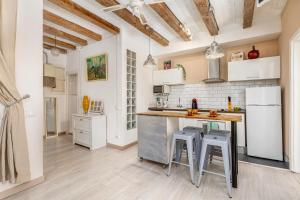 a kitchen with white appliances and a counter with stools at Retro Chic In Poble Sec in Barcelona