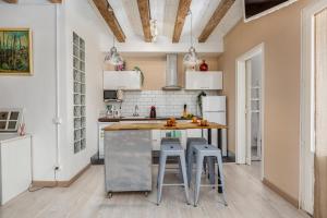 a kitchen with a counter and stools in a room at Retro Chic In Poble Sec in Barcelona