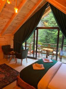 a bedroom with a bed and a large window at Hoşdere Bungalov in Çamlıhemşin +147 photos