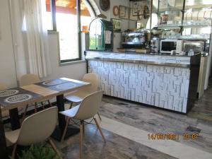 a restaurant with a table and chairs and a counter at Hotel Tropical in Ostuni