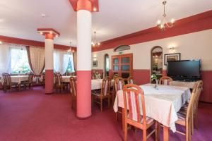 a dining room with tables and chairs and a flat screen tv at Dom Gościnny Emilia in Pobierowo