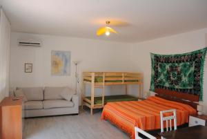 a bedroom with a bed and a couch and a bunk bed at Summer Beach Rooms in Fontane Bianche