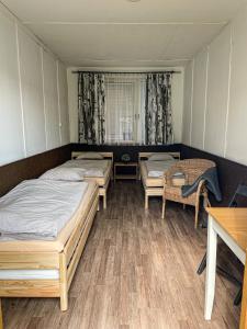 two beds in a room with a table and chairs at Camp Alpa in Ostrovačice