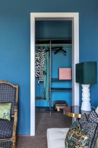 Cette chambre est dotée de murs bleus, d'une chaise et d'une table. dans l'établissement 4F Boutique Hotel Florence, à Florence