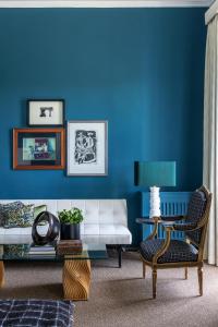 a living room with blue walls and a white couch at 4F Boutique Hotel Florence in Florence