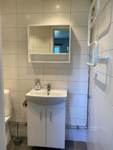 a bathroom with a white sink and a mirror at Gårdshus i Borgholm, Öland in Borgholm