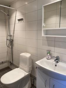 a white bathroom with a toilet and a sink at Gårdshus i Borgholm, Öland in Borgholm