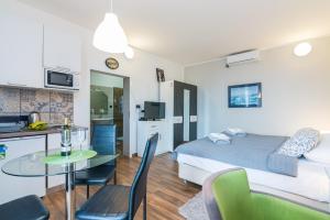 um quarto com uma cama, uma mesa e uma cozinha em Apartman Chiara em Rijeka