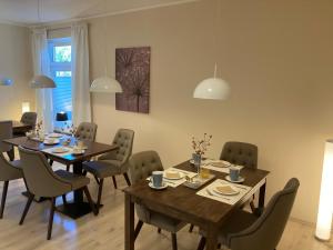 a dining room with wooden tables and chairs at City Hotel Gifhorn in Gifhorn