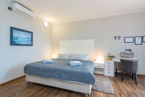 um quarto com uma cama, uma secretária e uma cadeira em Apartman Chiara em Rijeka