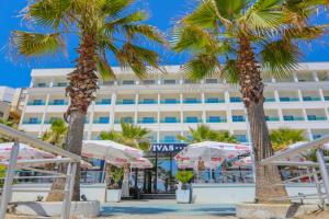 een hotel op het strand met palmbomen en parasols bij Hotel Vivas in Durrës