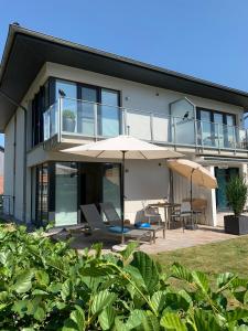 a house with an umbrella and a table and chairs at Beach Home in Sankt Peter-Ording