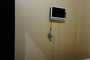 een tv aan de muur met een videogame controller bij Guest House Syariah LP3B Brebes RedPartner in Brebes