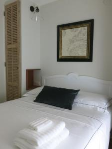 a white bed with two towels on top of it at Les Petits Volets 3 appartements au choix in Antibes